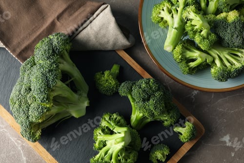 Preview: Board and plate with broccoli on grey table, top view. Healthy food