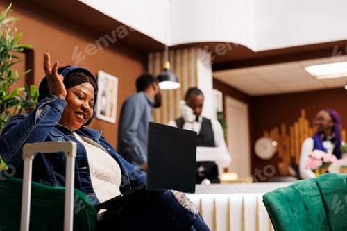 Preview: Happy woman talk via video call in hotel