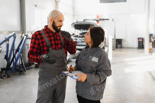 Preview: Male and female mechanics working on car