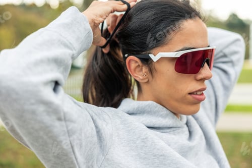 Preview: Latin woman preparing for fitness activity outdoors
