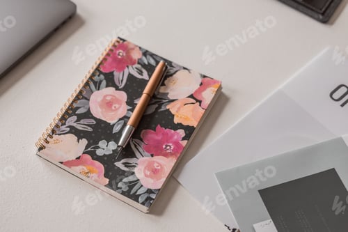 Preview: Aesthetic floral notebook and pen on a table