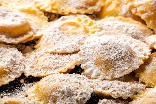Preview: Tasty raw ravioli with flour and basil on wood table