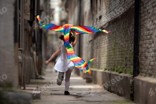 A child runs with a kite.