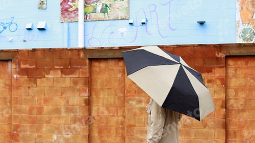Preview: Man with umbrella walking on the street