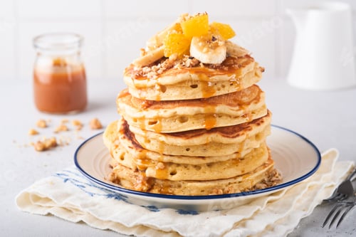 Preview: Pancakes. Homemade fluffy pancake with banana, walnut and caramel for breakfast on light concrete ba