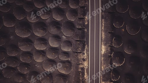 Preview: Aerial view of unusual and scenic asphalt straight road with black ground and holes. Rare vineyard