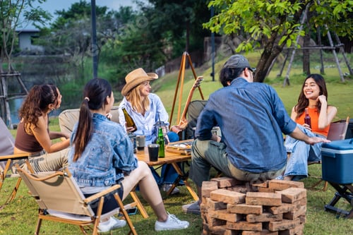 Preview: Group of diverse friend having outdoors camping party together in tent.
