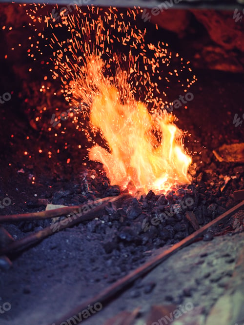 Preview: Unrecognizable blacksmith burning metal in furnace