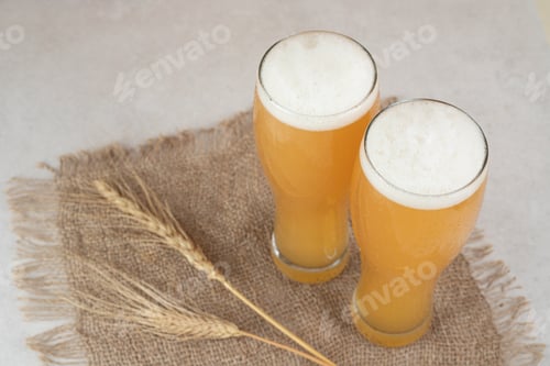 Preview: Two glasses of beer on burlap with wheat