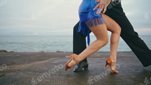 Preview: Feet unknown dance couple performing latin choreography on cloudy shore close up