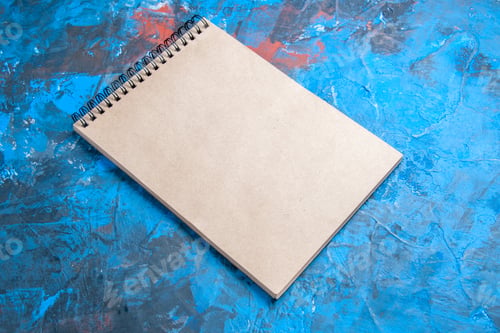Preview: front view a notepad on blue background with copy space