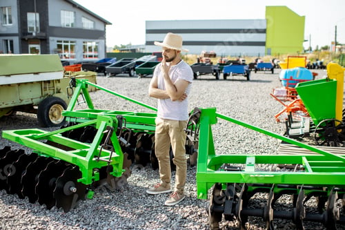 Preview: Agronomist at the shop ground with agricultural machinery