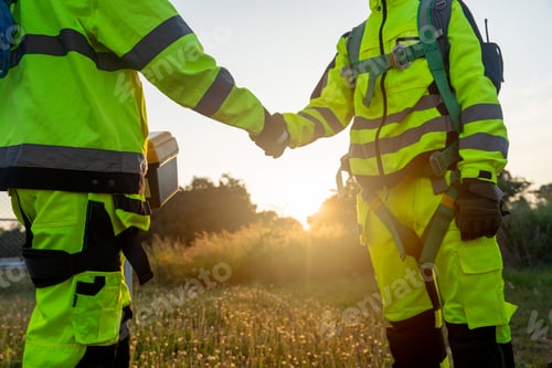 Preview: Close up two of wind turbine or windmill workers or technician shake hands and stand in workplace