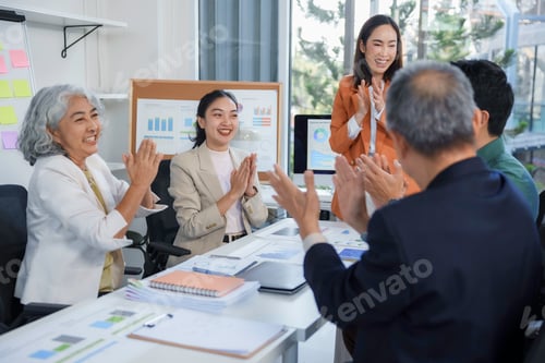 Preview: Business team clapping hands during a meeting in the office