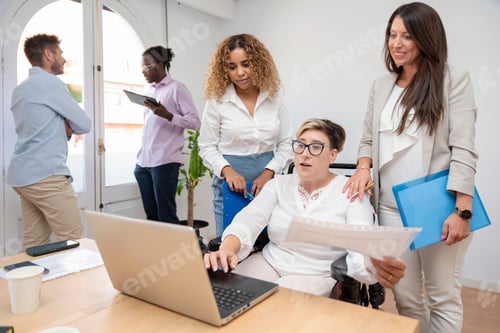 Preview: businesswoman with a disability sitting in a wheelchair in front of a laptop leads a meeting