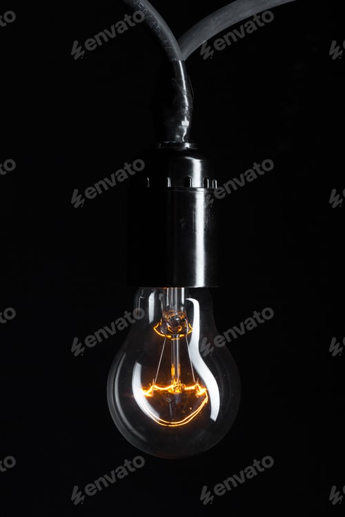 Preview: A classic Edison light bulb on dark background with space for text