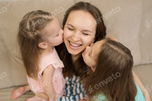 Preview: Two daughters kissing their mommy