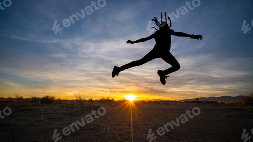 Preview: Girl with dreadlocks leaping against the backdrop of the sky at sunrise