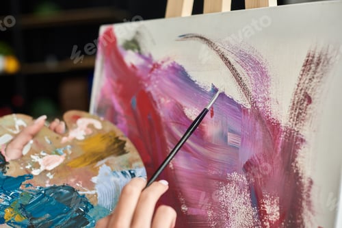 Preview: Young woman with short hair creates vibrant artwork at home during her artistic weekend