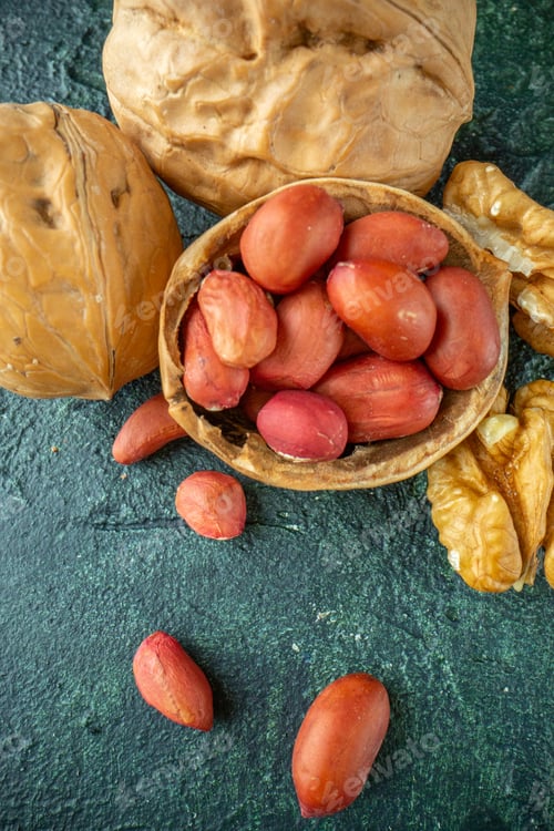 Preview: Close up view of broken walnuts peanuts on blue and yellow mixed colors background with free space