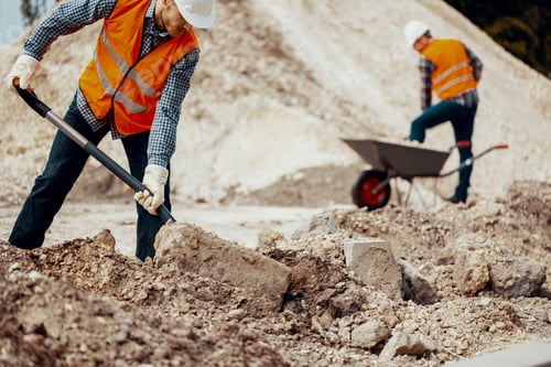 Preview: Worker in reflective vest and white helmet during physical work