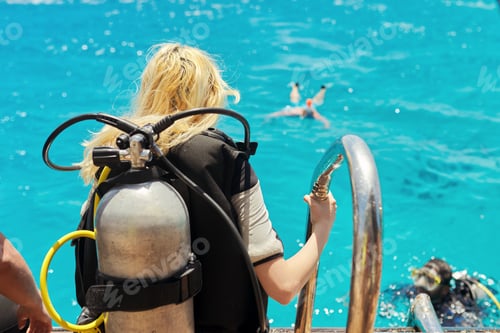 Preview: Young woman diver preparing for scuba diving