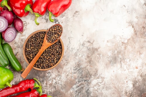 Preview: Top view of black pepper various chopped and whole vegetables on mixed color background