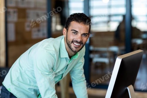 Preview: Desktop computer monitor displaying data on desk in modern office with wooden pinboard behind
