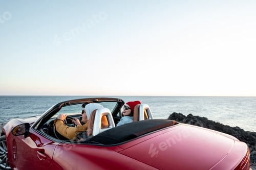Preview: Couple driving convertible car near the ocean