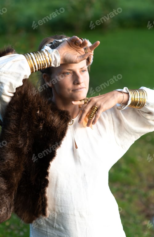 Preview: Harmonious calm woman with fur, feather ornaments, gilded copper rings and bracelets