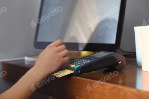 Preview: Woman using credit card machine for non cash payment in cafe, closeup