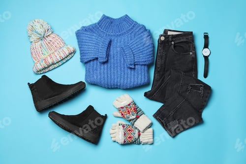 Preview: Flat lay composition with winter clothes and boots on light blue background