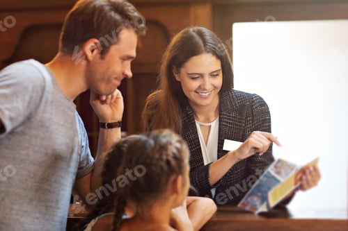 Preview: Happy family checking in hotel at reception desk