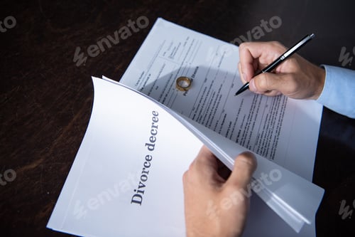 Preview: partial view of man sitting at table and signing divorce documents