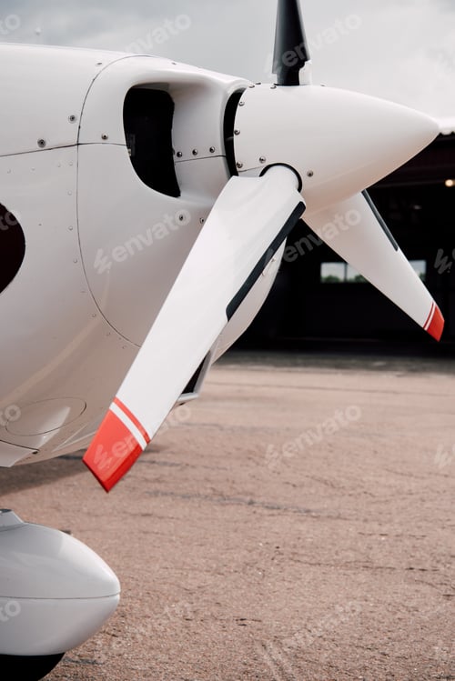 Preview: white plane with big propeller on ground under sky
