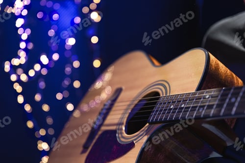 Preview: Close-up, acoustic guitar on a dark background with bokeh lights.