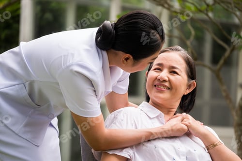 Vista previa: Beautiful nurse taking care of female patient at the hospital park