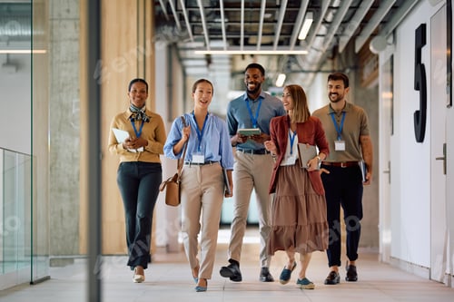 Preview: Happy diverse business colleagues walking through the office.