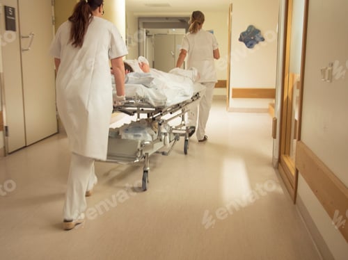 Preview: Nurse pushing patient on gurney in hospital