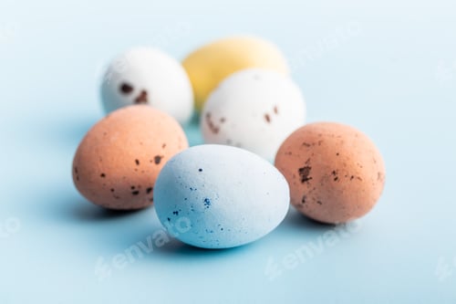 Preview: Colorful chocolate easter eggs. Sweet candy eggs on blue background.
