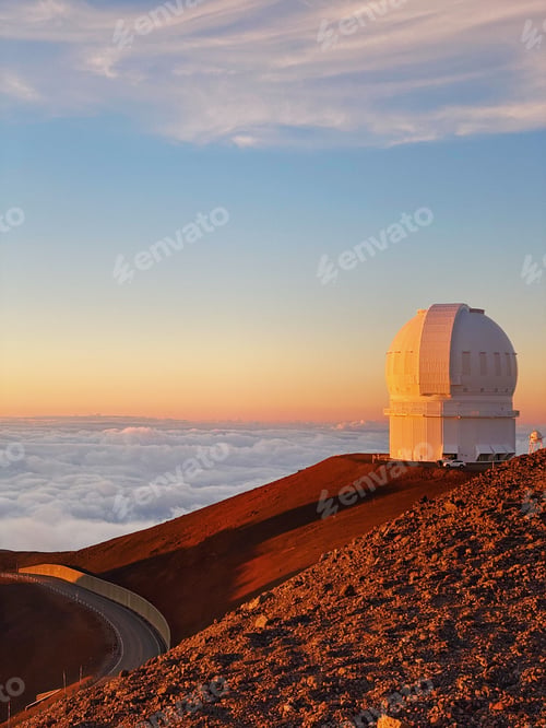 Preview: Vertical shot of the white building of Mauna Kea Observatories against a gorgeous gradient sunset