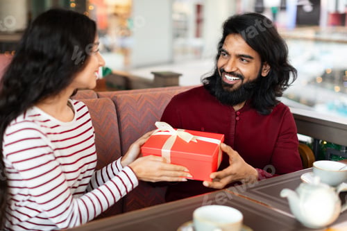Preview: Happy eastern couple celebrating birthday or anniversary at coffee shop