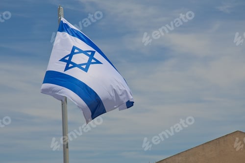 Preview: Flag of Israel on pole flutters in wind under blue sky. Israeli flag with the star of David