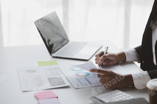 Preview: A female financier is reviewing company financial documents.