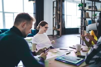 Preview: Young diverse colleagues discussing project in modern workspace
