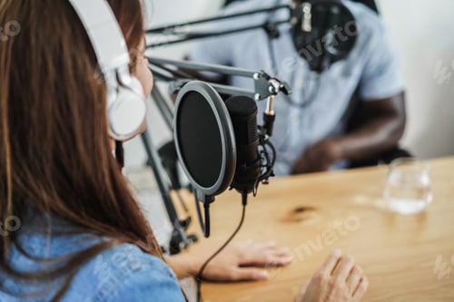 Preview: Multiracial hosts doing interview while streaming podcast together at home studio