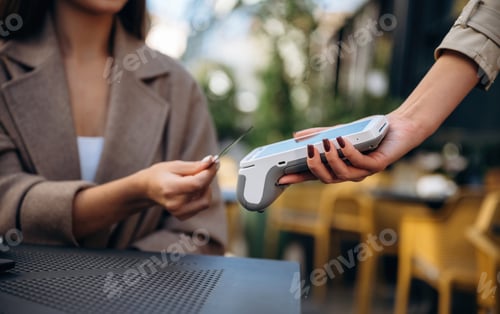 Preview: Woman is paying for food in cafe by using credit card. Conception of wireless money transfer