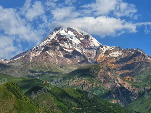 Preview: Mesmerizing scene of Mount Kazbek under a cloudy blue sky