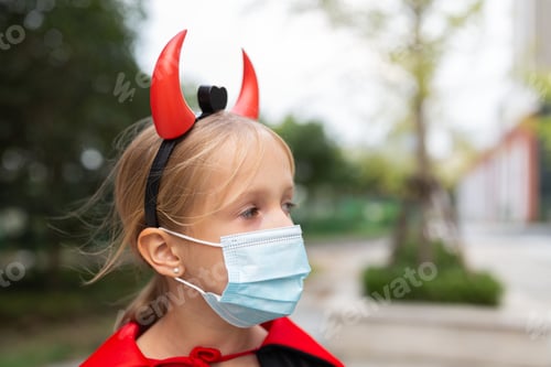 Preview: Happy kid in evil costume celebrating Halloween 2020 during coronavirus covid-19 pandemic