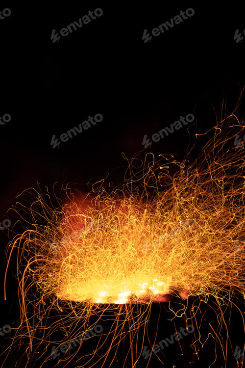 Preview: Campfire flame sparks long exposure isolated on black background. Fire sparkles long exposure